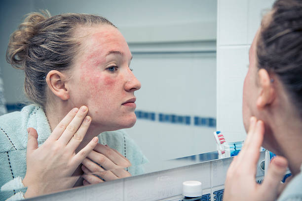 Woman Examining Acne in Mirror